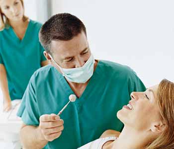 Image of a Dentist checking patient's mouth